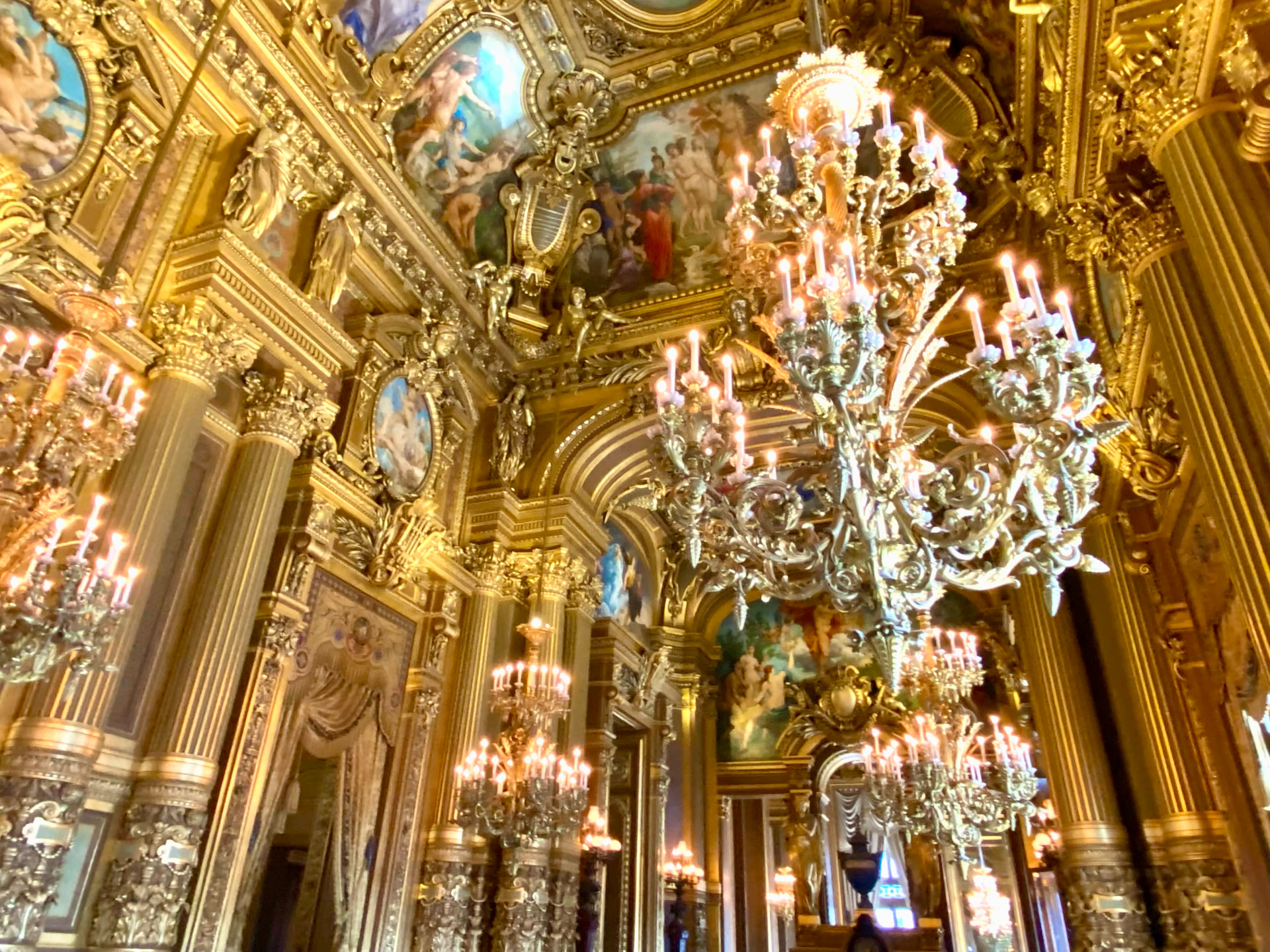 Gilded chandeliers and painted ceilings inside the Palais Garnier opera house