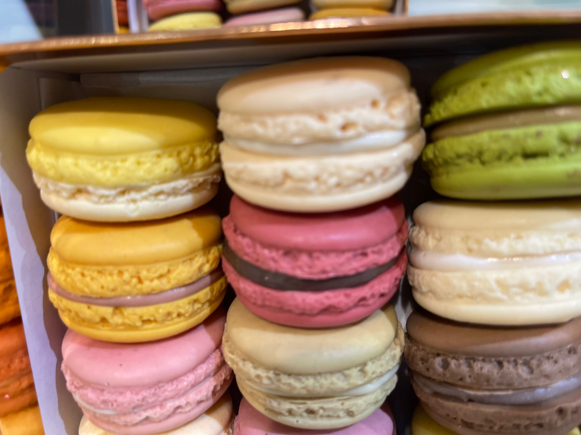 Trays of colorful French macarons in a Parisian pâtisserie