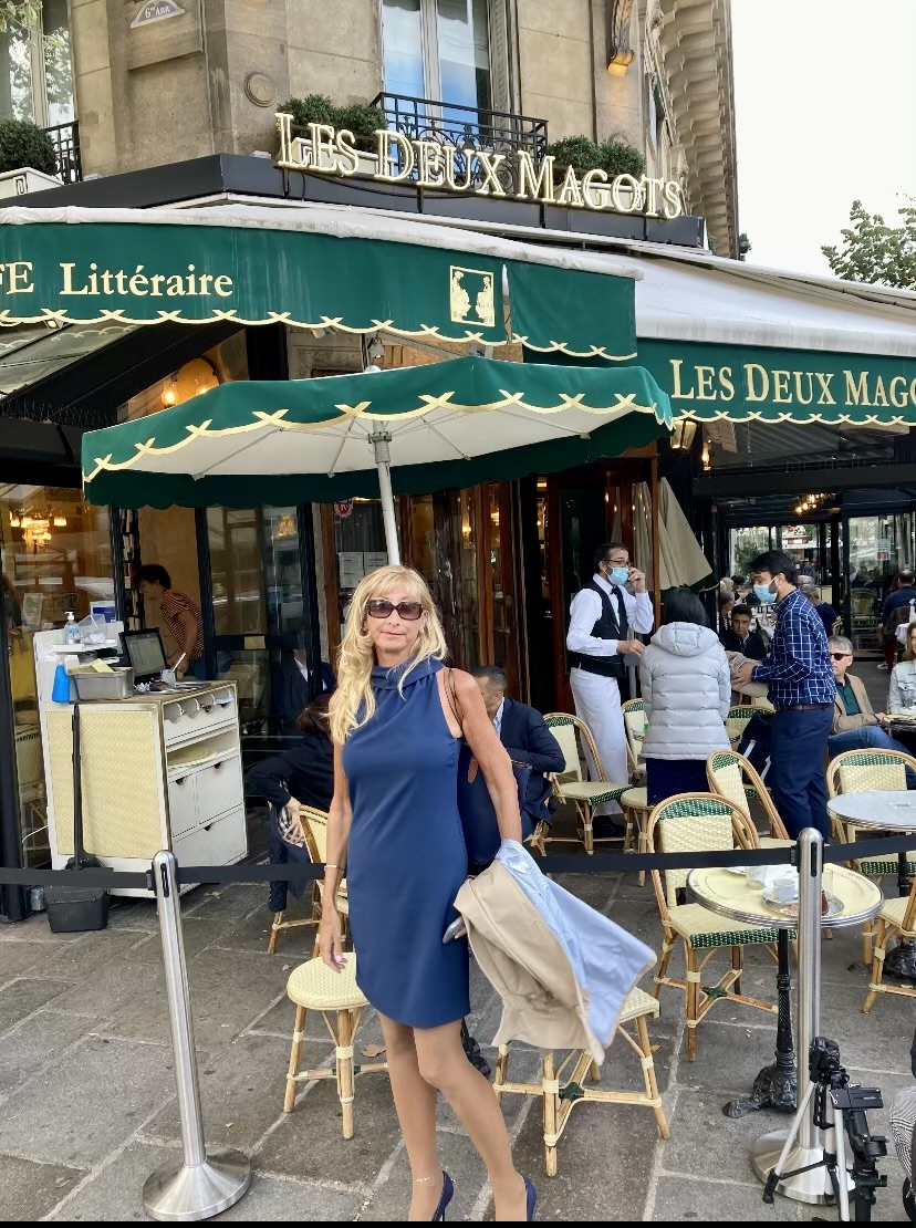 Classic Paris café terrace with woven chairs and marble tables in the morning light