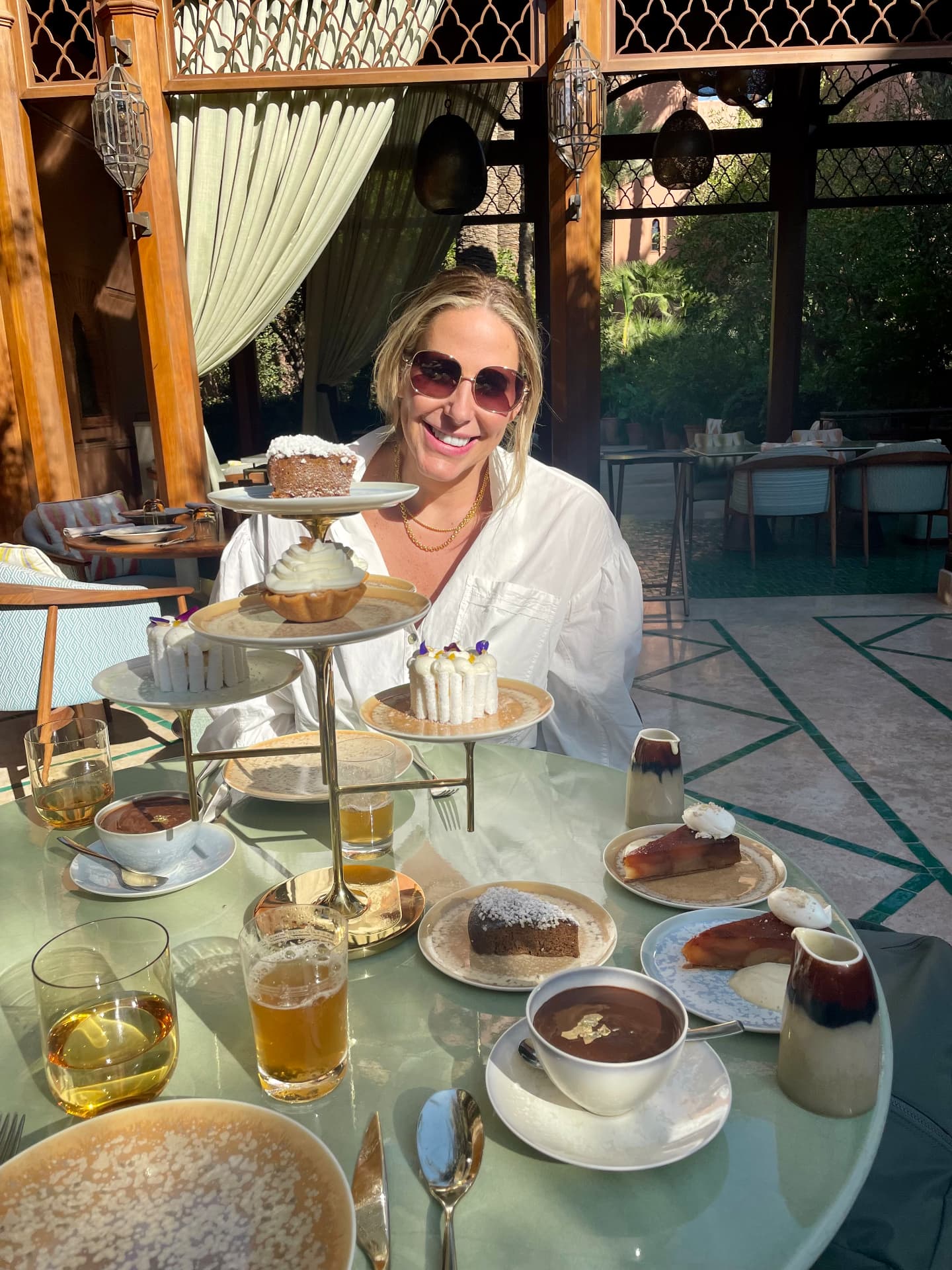 Woman enjoying afternoon tea and desserts on an ornate Moroccan palace terrace