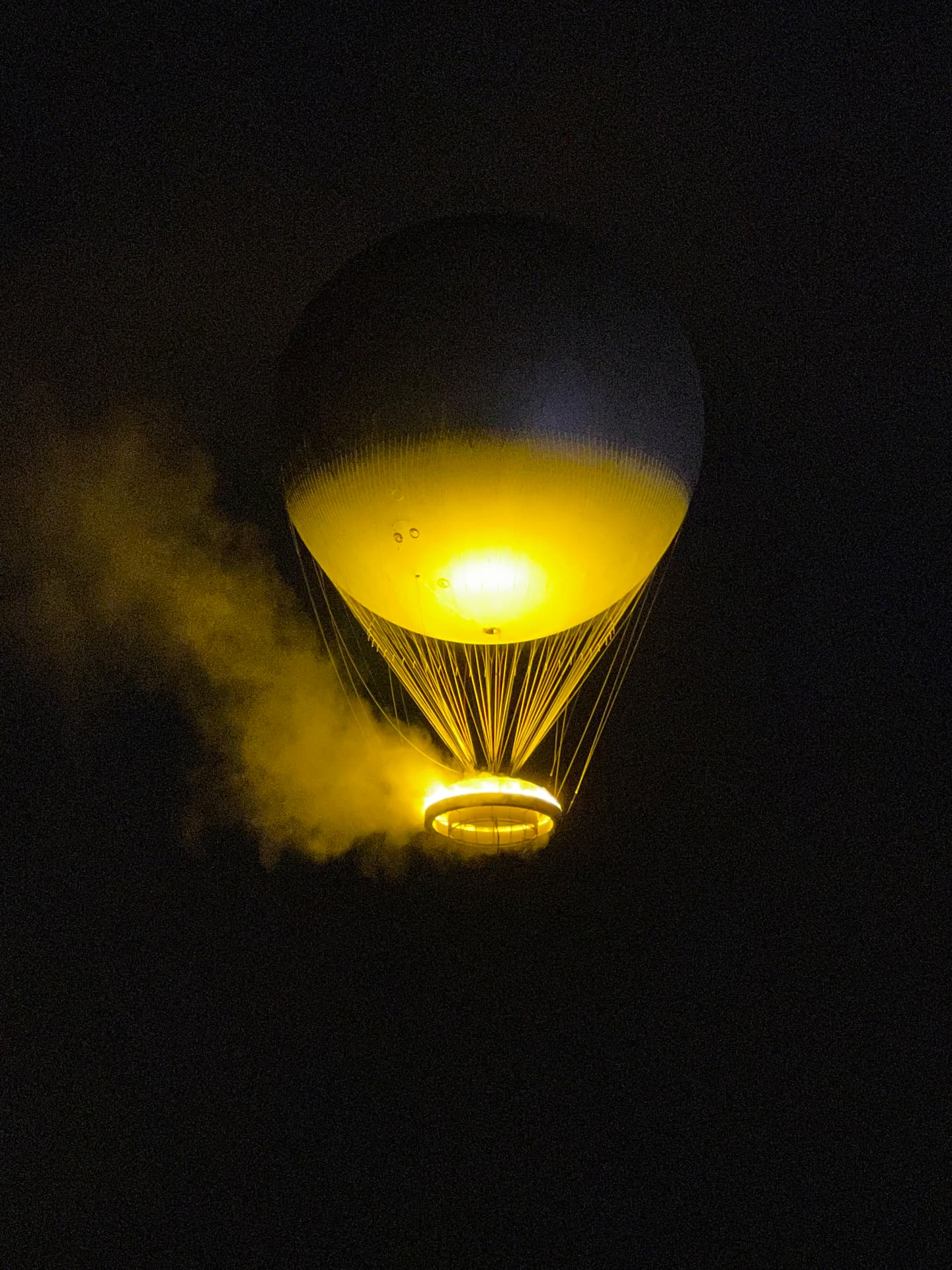 Hot-air balloon glowing over Paris at night
