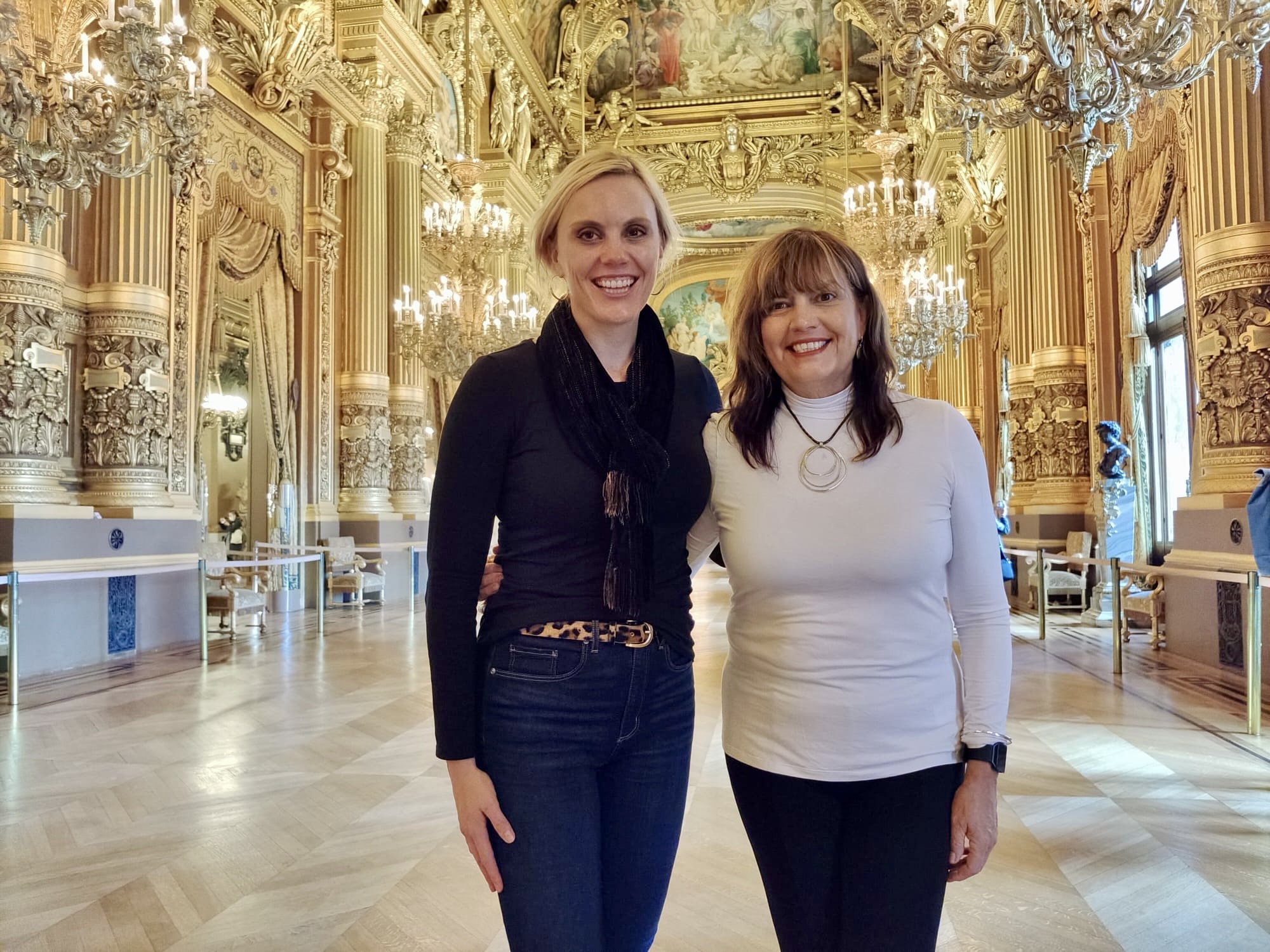 Two friends in the gilded Grand Foyer of the Palais Garnier opera house in Paris