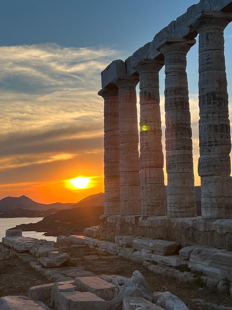 Sunset over the sea beyond an ancient Greek temple at Cape Sounion