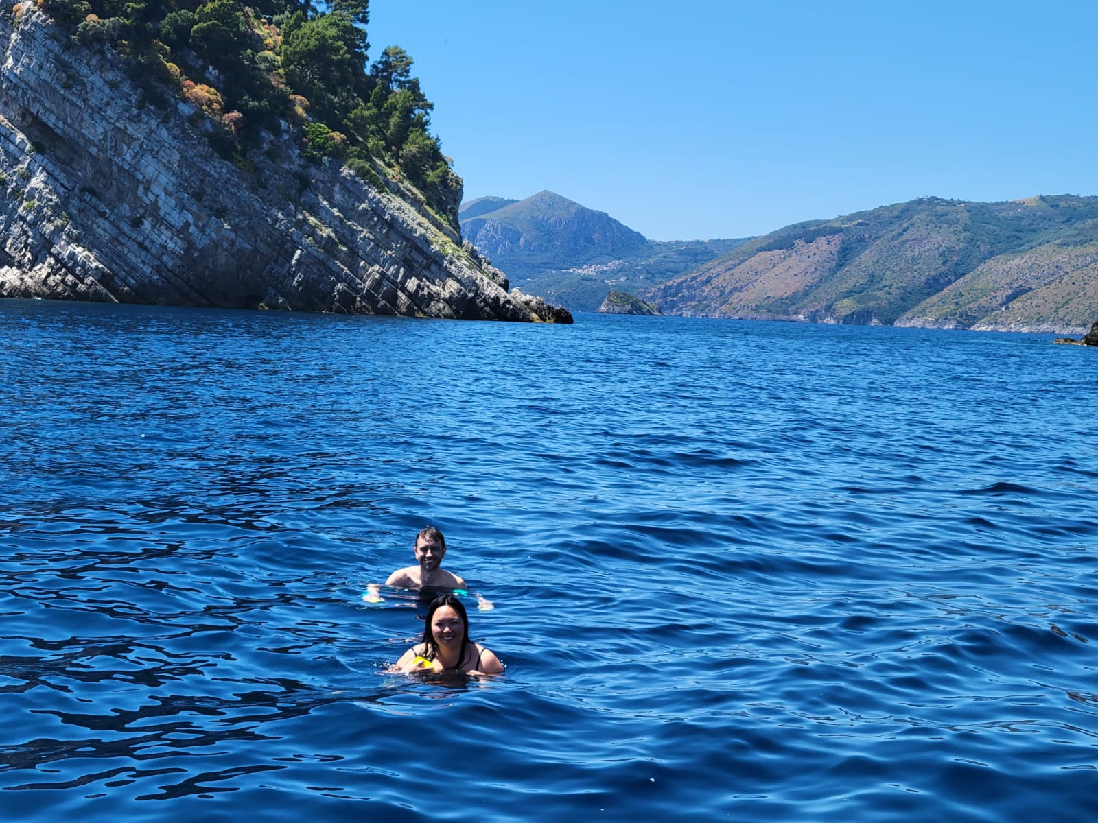 Couple swimming in a turquoise cove on the Amalfi Coast