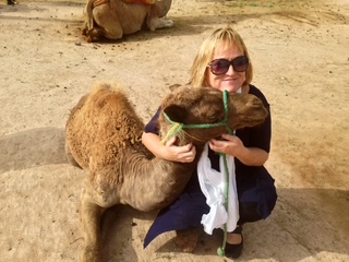 Traveler hugging a young camel in Morocco